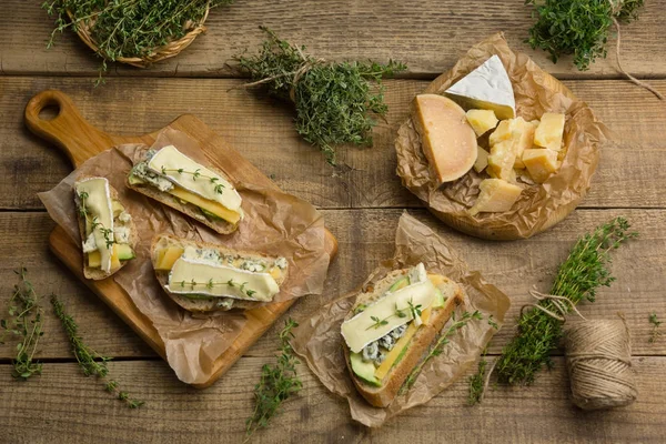 Sándwiches saludables con aguacate, queso y hierbas. En bac de madera — Foto de Stock