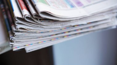 Gazeteler ve katlanmış bir yığın masanın üzerine yığılmış. Günlük gazete haber iş ofis, finans ve iletişim kavramı ile. Yan görünüm, seçici odak