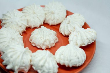 Beyaz bir zemin üzerinde kırmızı bir uçan daire ile marşmelovlar