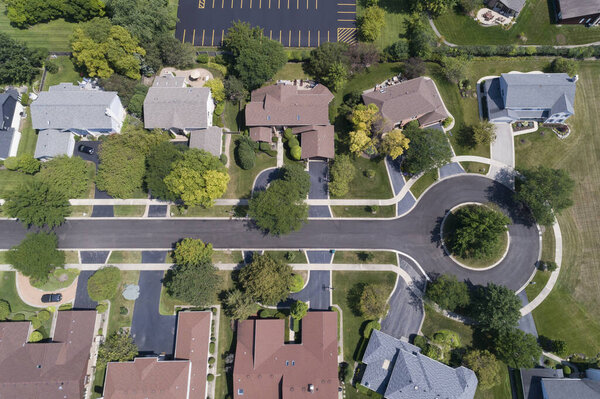 Aerial view of a tree-lined neighborhood in a cul-de-sac in a Chicago suburban city in summer.