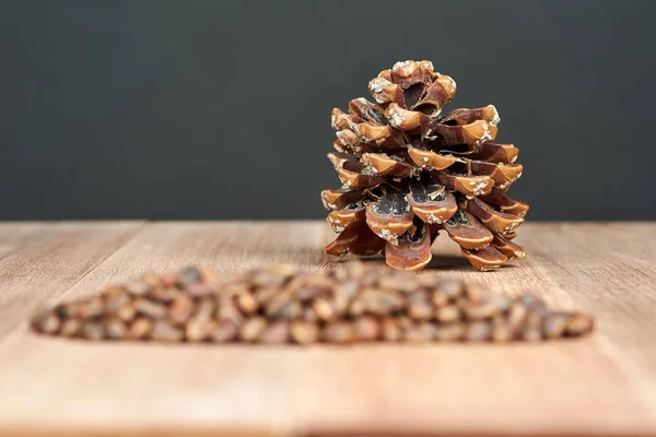 Pine nuts with cones on mahogany boards.