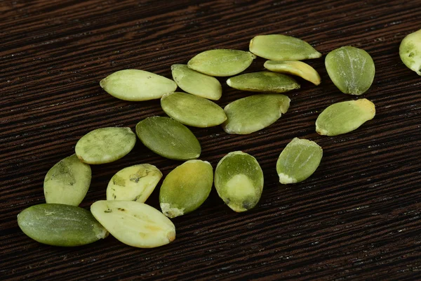 Un mucchio di semi di zucca sullo sfondo di un albero . — Foto Stock