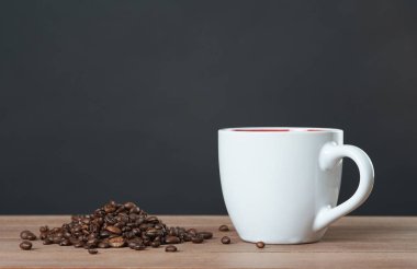 Dağınık kahve çekirdekleri ile kahve kupa.