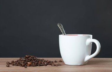 Dağınık kahve çekirdekleri ile kahve kupa.