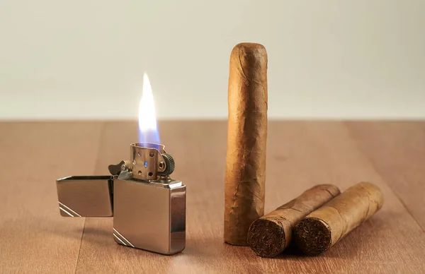 Cigarrer med en brinnande bensin lättare. — Stockfoto