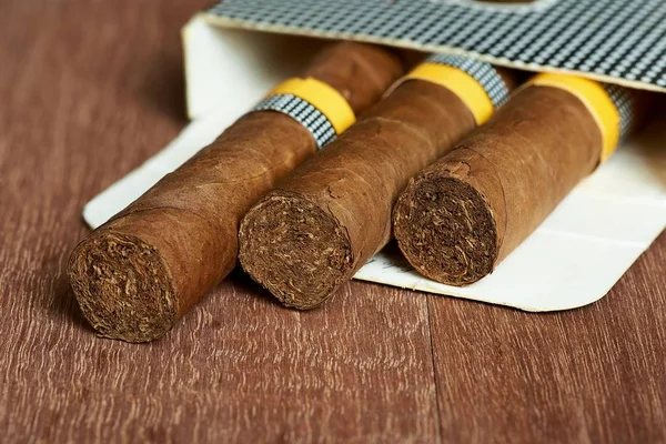 Cigarrer i paketet på mahogny styrelser. — Stockfoto