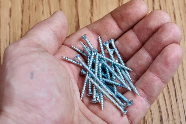 A lot of screws in the hand — Stock Photo, Image