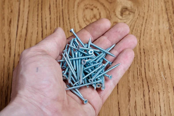 A lot of screws in the hand — Stock Photo, Image