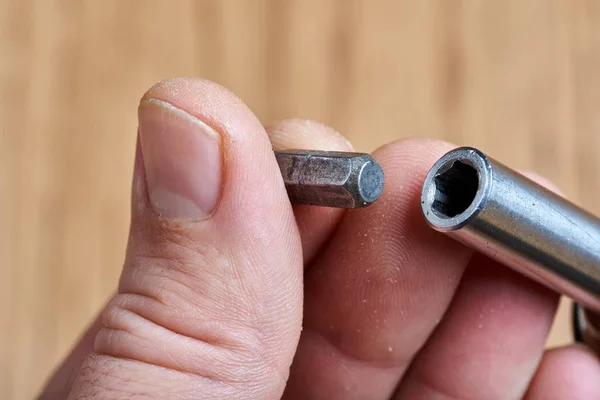 A man inserts a bit into the screwdriver. — Stock Photo, Image