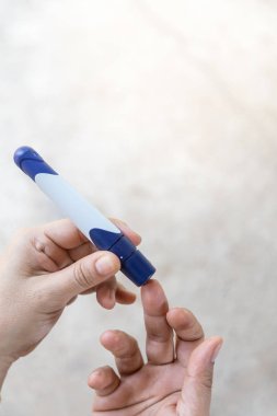 Lancet kan su kontrol etmek için parmağına kullanarak kadın elinde yakın çekim