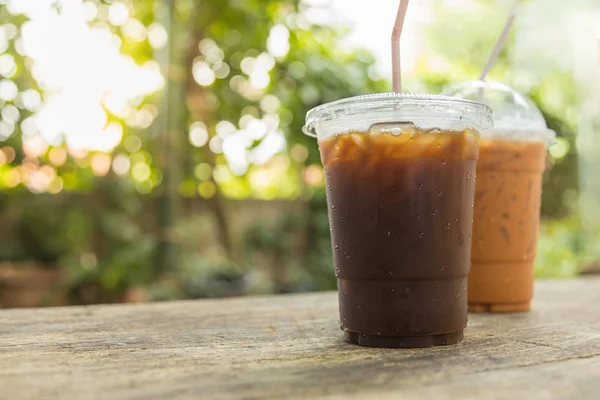 Gros plan de deux à emporter tasse en plastique de café noir glacé (Amer — Photo