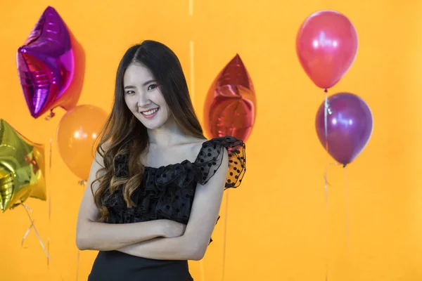 Portret van een glimlachende mooie jonge Aziatische vrouw met gele muur — Stockfoto