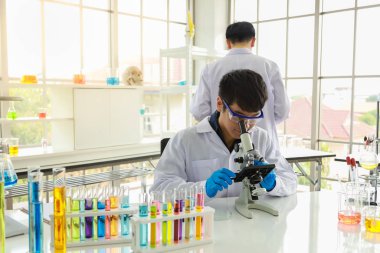 Two asian professional senior and young doctor scientist using m