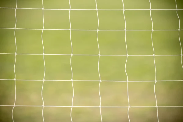 Close up of white football / soccer goal net with green grass as — Stock Photo, Image