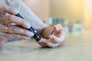 Kan şekeri seviyesini Glikoz ölçer ile ölçmek için parmağa mızrak kullanarak insan elini kapat. İlaç, diyabet, glisemi, sağlık hizmetleri ve insanların konsepti olarak kullan.