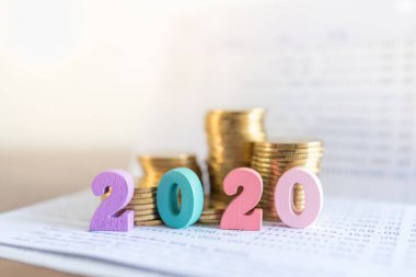 2020 Yeni Yıl, İş, Tasarruf ve Planlama Konsepti. Banka hesap defterindeki renkli ahşap numarayı kopyalama alanı olan altın paralarla kapat.