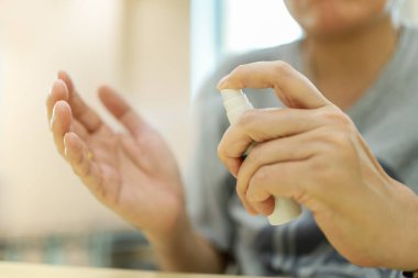 Sağlık, Sağlık ve Virüs Koruma Konsepti. İnsan eli ele tutuşup küçük bir şişe alkol kullanarak Coronavirus 'u fotokopi alanıyla korumak için temizleme eline% 70 sprey sıkın..