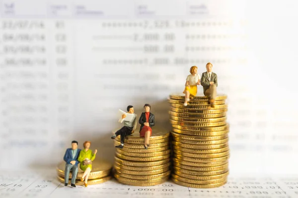 Business, Money, Financial, Secure and Saving Concept. Group of businessman and woman miniature figure people sitting and talking meeting on stack of gold coins on bank passbook.
