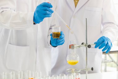 İki doktor bilim adamı pipeti laboratuarda test ve araştırma yapmak için kullanıyor. Sağlık, Coronavirus (Covid-19) Koruma Konsepti.