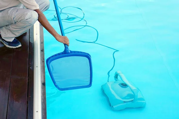 Funcionário do hotel limpando a piscina — Fotografia de Stock