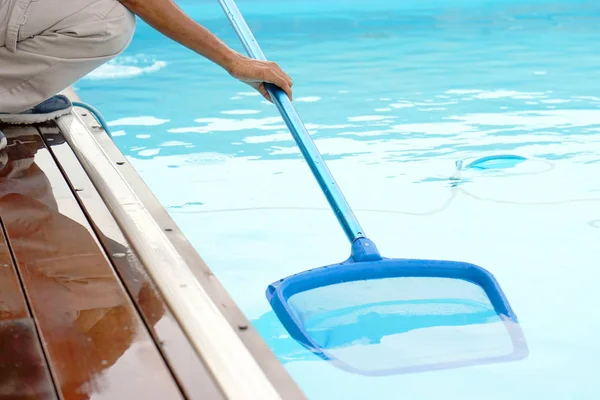 Funcionário do hotel limpando a piscina — Fotografia de Stock