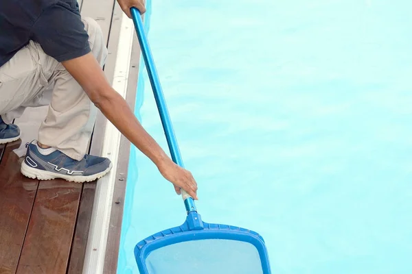 Funcionário do hotel limpando a piscina — Fotografia de Stock