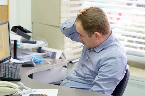 Man met een hoofdpijn achter de computer — Stockfoto