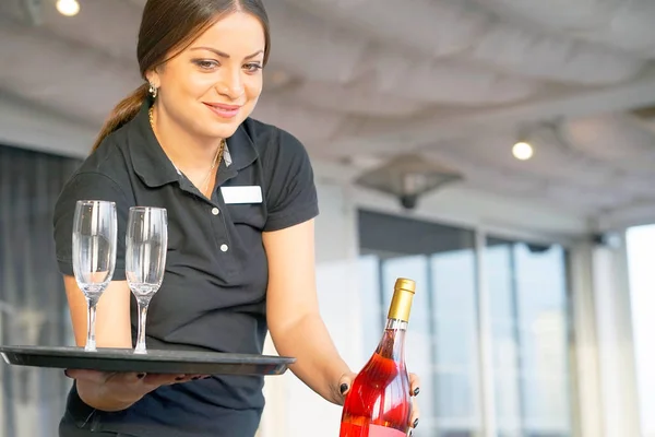 La camarera lleva una botella de vino. —  Fotos de Stock
