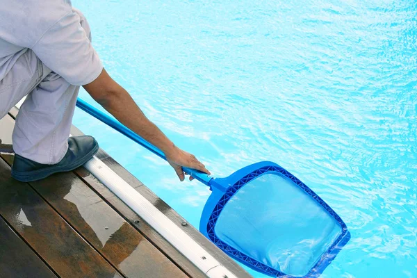 Funcionário do hotel limpando a piscina — Fotografia de Stock