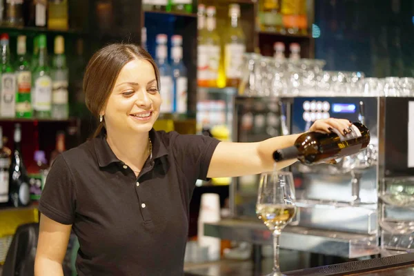 Ragazza barista versa il vino in un bicchiere di vino — Foto Stock