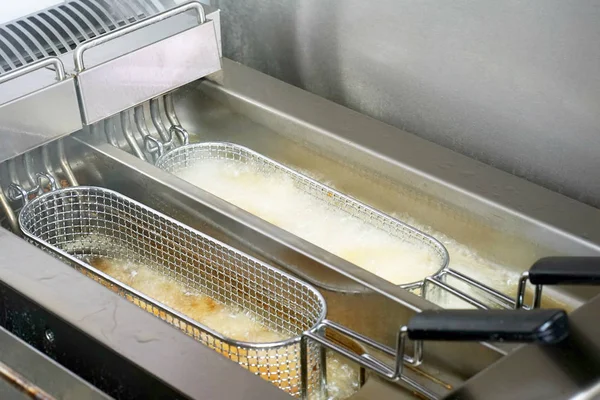 French fries in deep fryer, closeup