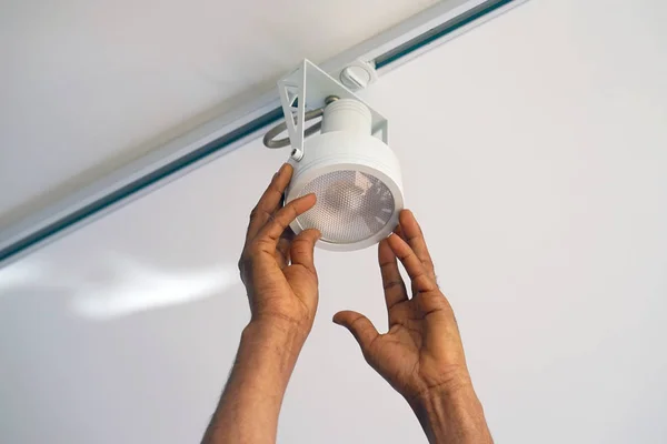 Trabalhador homem eletricista instalando um teto LED holofotes — Fotografia de Stock