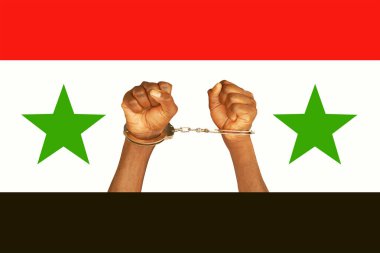 Elleri kelepçeli kilitli. Suriye bayrağı.