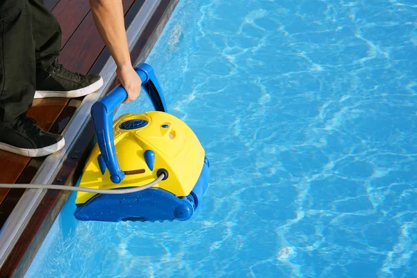 Funcionário do hotel a limpar a piscina. Limpadores de piscina automáticos . — Fotografia de Stock