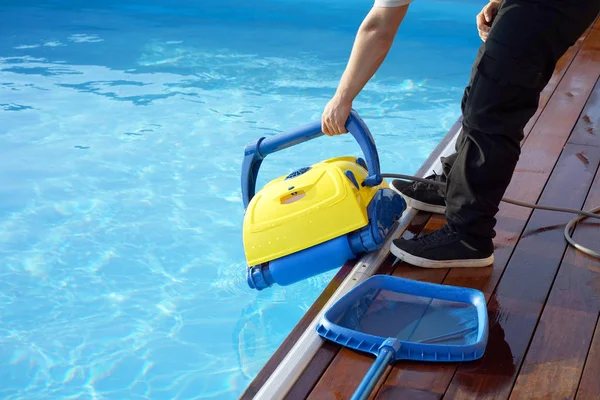 Funcionário do hotel a limpar a piscina. Limpadores de piscina automáticos . — Fotografia de Stock