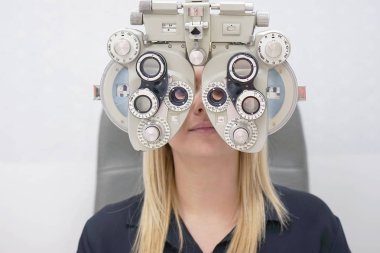 Kadın Optometrist yapıyor görme testi için kadın hasta içinde kliniği