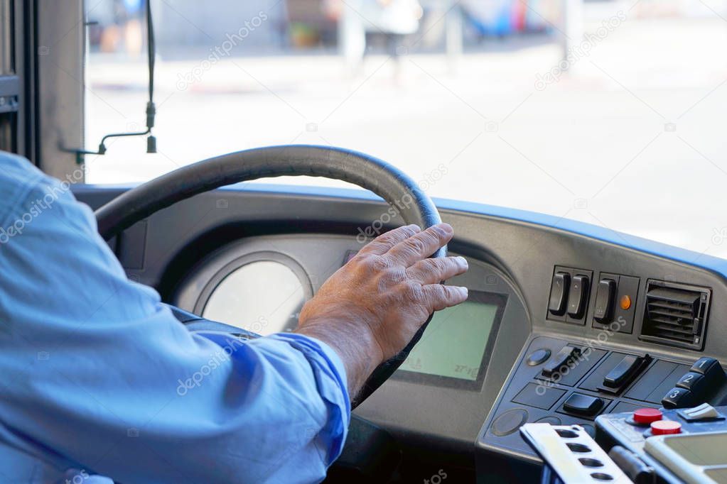 cropped shot of bus driver holding steering whee