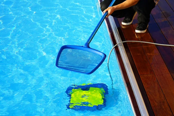 Trabajador del hotel limpiando la piscina. Limpiadores automáticos de piscinas . —  Fotos de Stock
