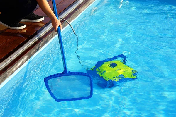 Trabajador del hotel limpiando la piscina. Limpiadores automáticos de piscinas . — Foto de Stock