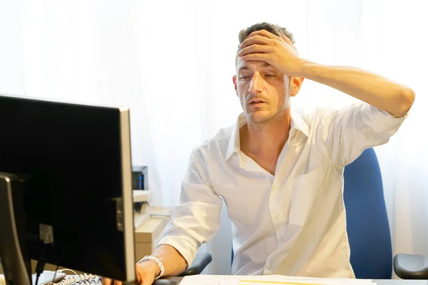 Mann mit Kopfschmerzen vor dem Computer — Stockfoto