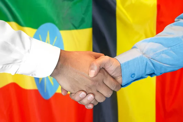 Apretón de manos en Etiopía y Bélgica bandera de fondo . — Foto de Stock