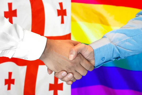 Stretta di mano su georgia e LGBT gay bandiera sfondo . — Foto Stock