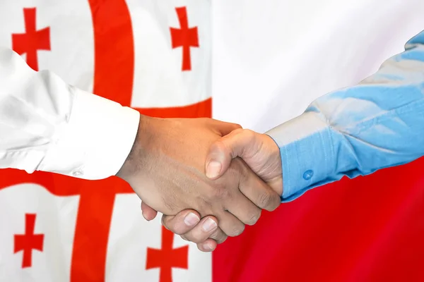 Handshake no fundo da bandeira da Geórgia e da Polónia . — Fotografia de Stock