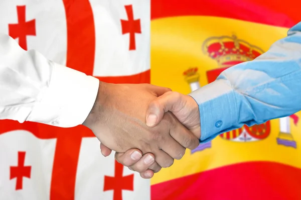 Aperto de mão sobre fundo bandeira Geórgia e Espanha . — Fotografia de Stock