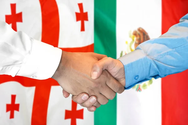 Apretón de manos sobre el fondo de la bandera de Georgia y México . — Foto de Stock
