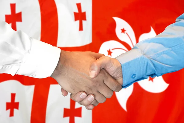 Handshake on Georgia and Hong Kong flag background.