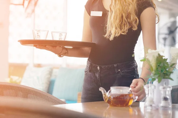 Chica trabajando como camarera sosteniendo una bandeja con té —  Fotos de Stock