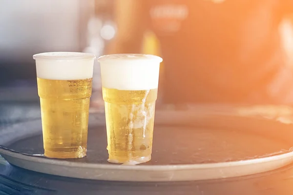 Two plastic glasses of beer