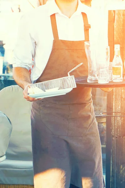 Waiter carries dirty dishes. The concept of service. — Stock Photo, Image