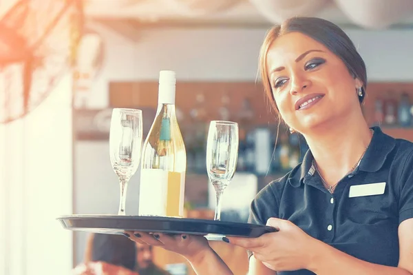 De serveerster is het dragen van een fles wijn — Stockfoto